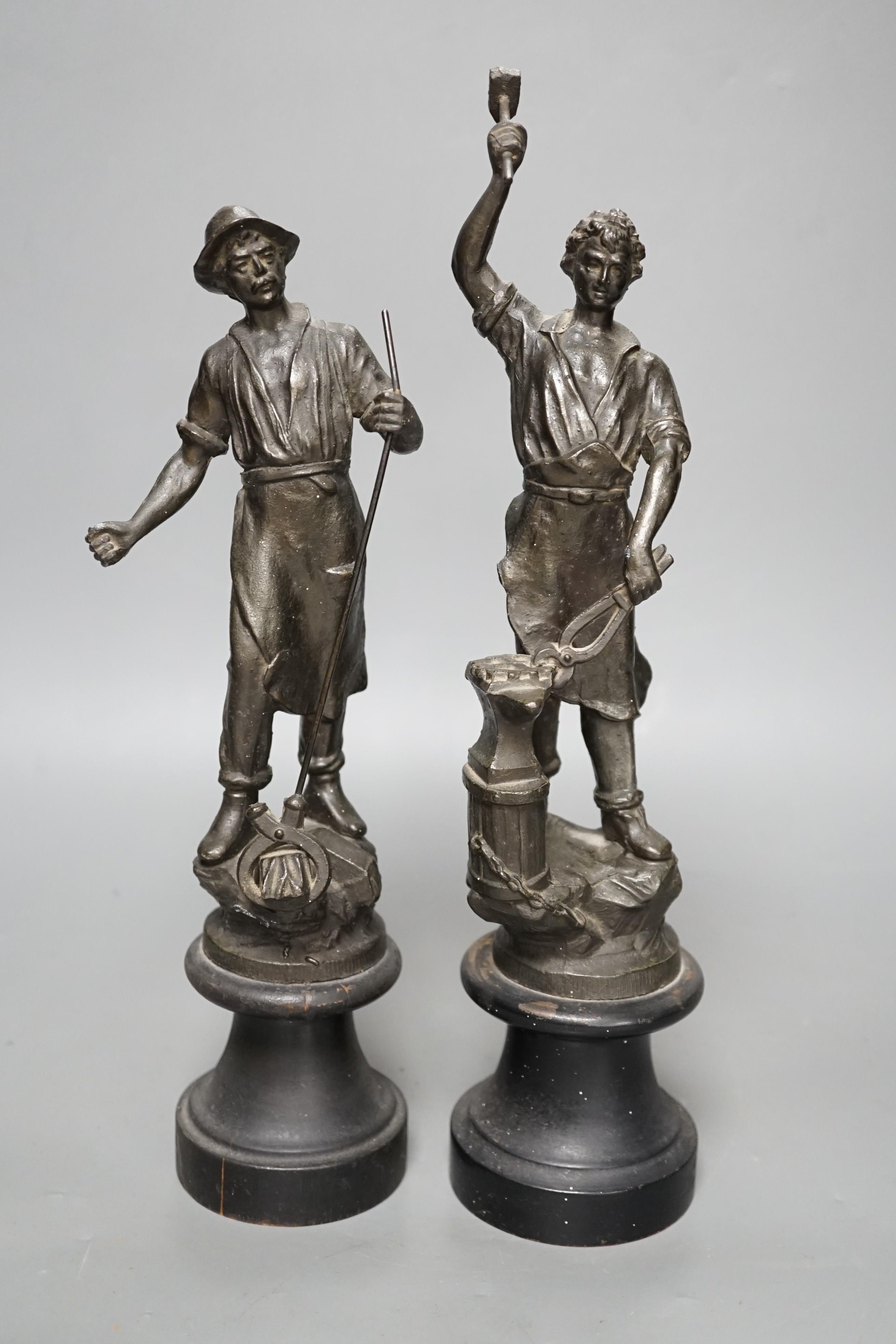 A pair of spelter blacksmith figures, tallest 34cms high